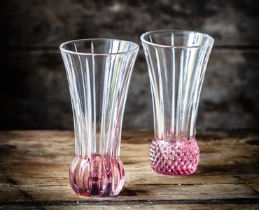 2 NACHTMANN Spring Vase Rosé side by side on white background. The upper part of the vase is clear crystal glass while the base is textured rose coloured crystal glass.