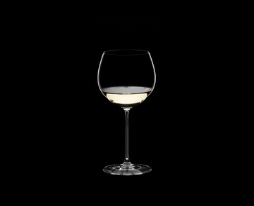 RIEDEL Veritas Restaurant Oaked Chardonnay filled with a drink on a black background