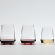 Wine filled SL RIEDEL Stemless Wings Cabernet Sauvignon glass, Pinot Noir / Nebbiolo and Riesling / Champagne Glass stand side by side on a grey surface.
