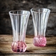 2 NACHTMANN Spring Vase Rosé side by side on white background. The upper part of the vase is clear crystal glass while the base is textured rose coloured crystal glass.