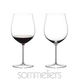 Two RIEDEL Sommeliers Burgundy Grand Cru glasses on white background. The glass on the left side is filled with red wine, the one on the right side is empty.