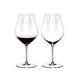 Two RIEDEL Performance Pinot Noir glasses side by side. The glass on the left side is filled with red wine, the other one is empty.