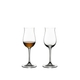 Two RIEDEL Vinum Cognac Hennessy glasses stand side by side. The glass on the left side is filled with Cognac, the other glass is empty.