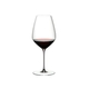 A RIEDEL Veloce Syrah/Shiraz glass filled with red wine on a white background.