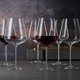 6 unfilled SPIEGELAU Definition Bordeaux Glasses stand slightly offset side by side on white background
