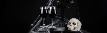 Halloween setting, two wine glasses, candelabra and skull