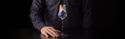 cocktail in RIEDEL glass with hand holding it