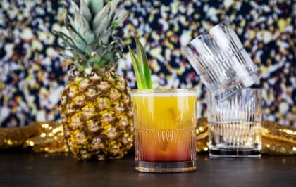 pineapple cocktail next to pineapple