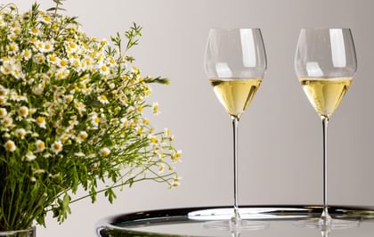two wine glasses next to wildflowers