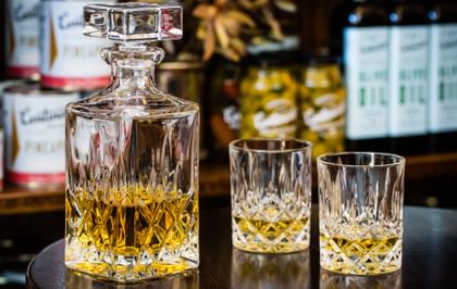 The Nachtmann Noblesse Whisky Set filled with Whisky on a glass table top.