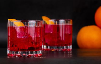 two cocktails next to oranges