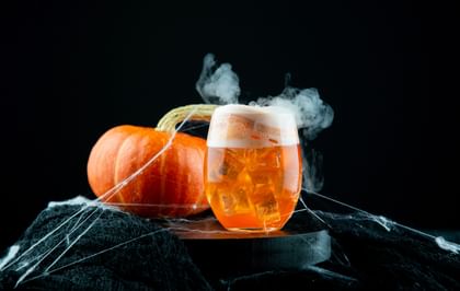 RIEDEL The O Wine Tumbler Cabernet/Merlot with a orange halloween cocktail in it and a pumkin as decoration