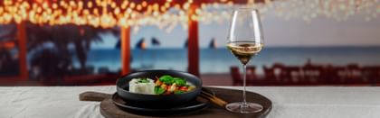 thai curry dish next to white wine glass
