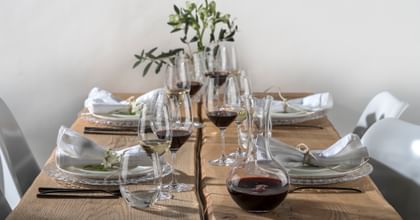 Table set with various Riedel glasses and a decanter filled with red wine
