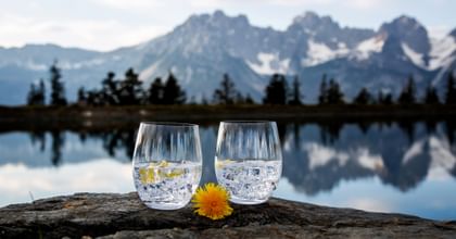two lime cocktails outside near lake