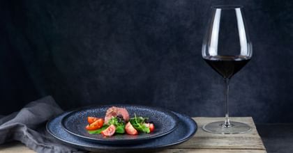 red wine next to steak on a plate