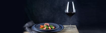 RIEDEL glassware next to a plated steak