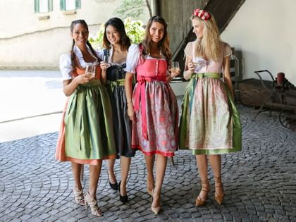 women in traditional Austrian dresses enjoying wine