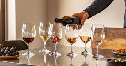 pouring wine into RIEDEL Ouverture glasses lined up