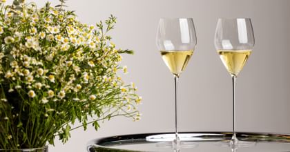two wine glasses next to wildflowers