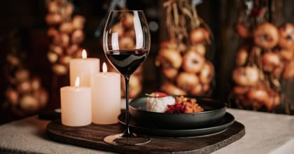 RIEDEL red wine glass next to candles and Spanish goulasch dish