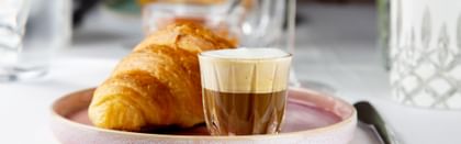 croissant next to coffe in RIEDEL glass