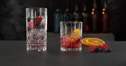 The NACHTMANN Highland Diamond longdrink glass filled with a berry cocktail on ice next to the Highland Diamond tumbler filled with a Negroni.<br/><br/>