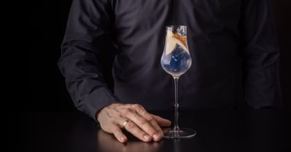 hand holding cocktail in RIEDEL glass