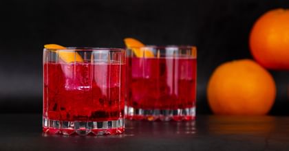 two cocktails next to oranges