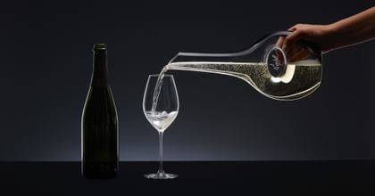 Champagne is poured from a decanter into a champagne glass