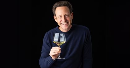 man holding white wine glass