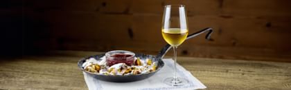 Authentic Austrian dish next to white wine glass