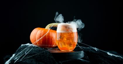 RIEDEL The O Wine Tumbler Cabernet/Merlot with a orange halloween cocktail in it and a pumkin as decoration