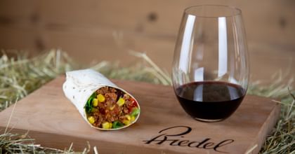 stemless red wine glass next to burrito
