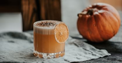 cocktail in RIEDEL glass next to pumpkin