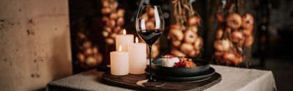 Spanish Gulash and red wine glass next to candles