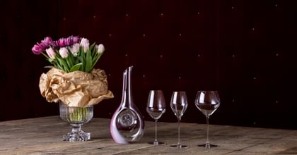 bouquet of flowers next to decanter and three wine glasses