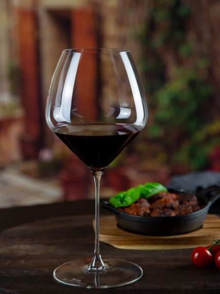 red wine glass next to food dish on table
