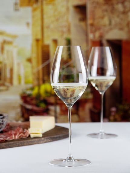 white wine glasses next to food dish on table