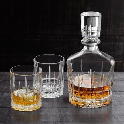 The with Whisky filled SPIEGELAU Perfect Serve Collection decanter next to two Perfect tumblers, one filled with Whisky on the rocks.<br/>