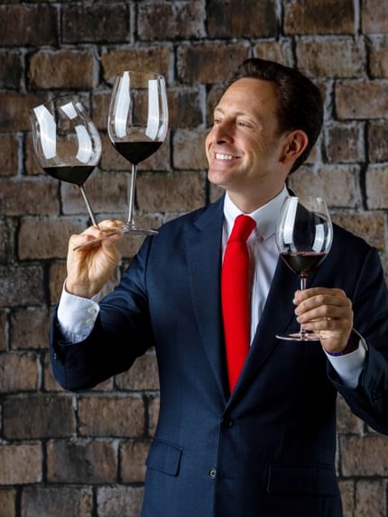 man holding three wine glasses