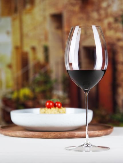 red wine glass next to food dish on table