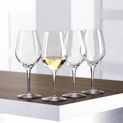 Quatre verres à vin blanc SPIEGELAU Authentis posés sur une table, dont l'un est rempli de vin blanc.<br/>