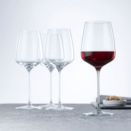 Quattro bicchieri da vino rosso SPIEGELAU Willsberger Anniversary, uno dei quali riempito di vino rosso.<br/>