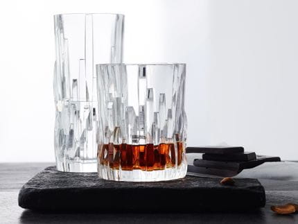 La serie NACHTMANN Shu Fa con el vaso longdrink y el con vaso relleno de whisky en una bandeja de piedra para servir.<br/>