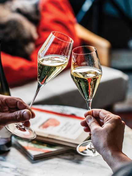 Two hands clinking two Spiegelau Definition Champagne glasses filled with Champagne.