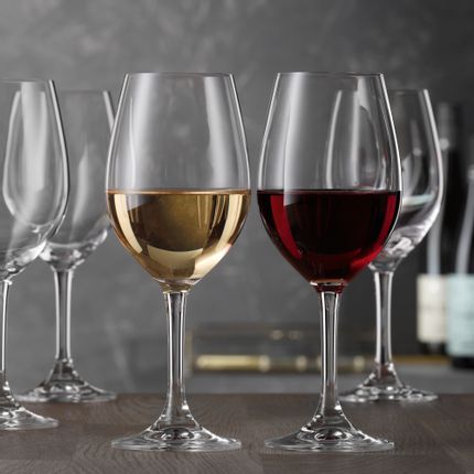 A group of SPIEGELAU Festival white wine glasses on a table. In the foreground one glass is filled with white wine and one glass with red wine, showing the universal use of these glasses.<br/>
