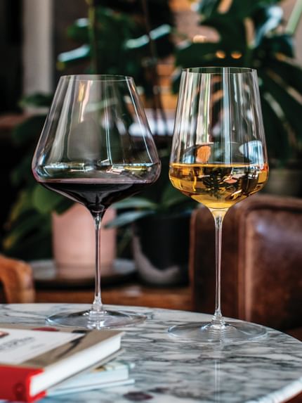 The Spiegelau Definition Burgundy glass and Spiegelau Definition Universal glass on a marble tabletop filled with wine.
