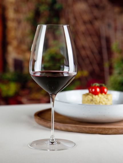 red wine glass next to food dish on table
