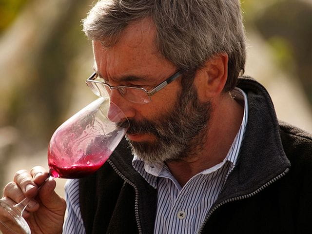 Man sniffing red wine out of a wine glass